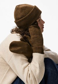 Gorro de lana marrón con puño acanalado y mitones marrones a juego con un acabado texturizado. Tela suave y acogedora combinada con un suéter beige claro.