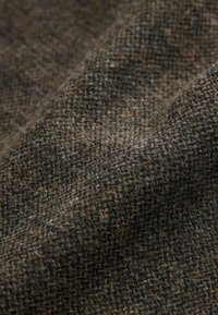Textured fabric in shades of brown, featuring a checked pattern. The material appears soft and woven, with a slightly fuzzy surface.