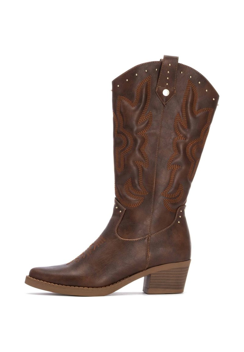 Bota de vaquero de cuero marrón con punta afilada, costuras decorativas, patrones en relieve y pequeños remaches en el caña y el tacón.