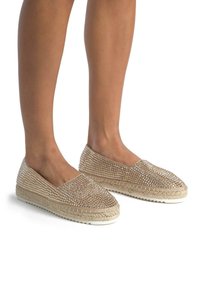 Espadillas beige claro con suela de yute trenzada, adornadas con strass transparentes en la parte superior, con un diseño de tipo slip-on y un perfil bajo.