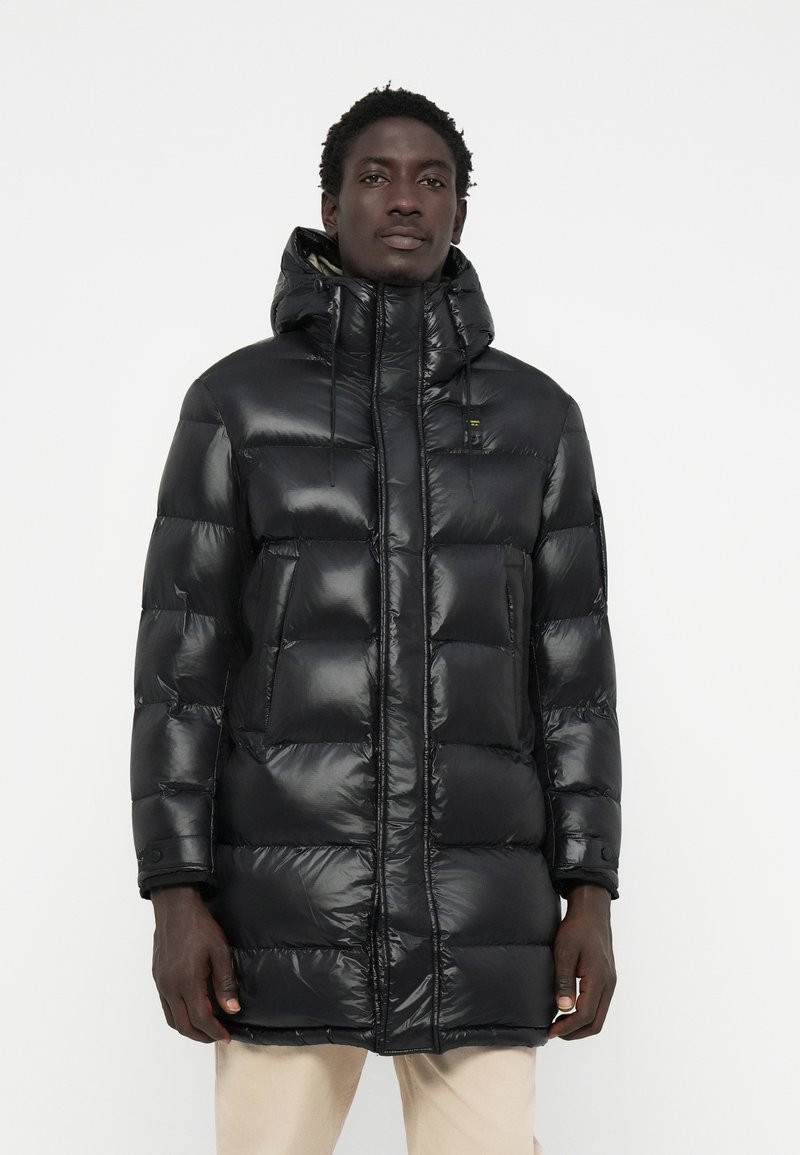Black puffer coat with a shiny finish, featuring a hood, zip closure, and side pockets. The design includes a quilted texture.