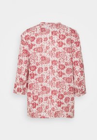 Bluse med blomstermønster i rød og hvid. Har trekvartærmer, rund halsudskæring og en løs pasform, lavet af letvægtsstof.
