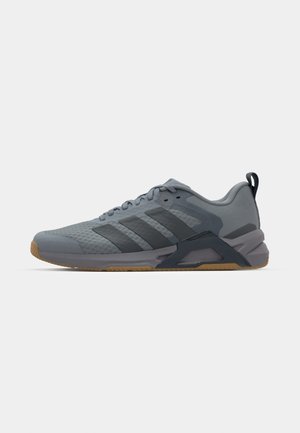 Baskets de sport grises avec un dessus texturé, trois rayures gris foncé, semelle en caoutchouc et contrefort de talon renforcé. Présente un design élégant.
