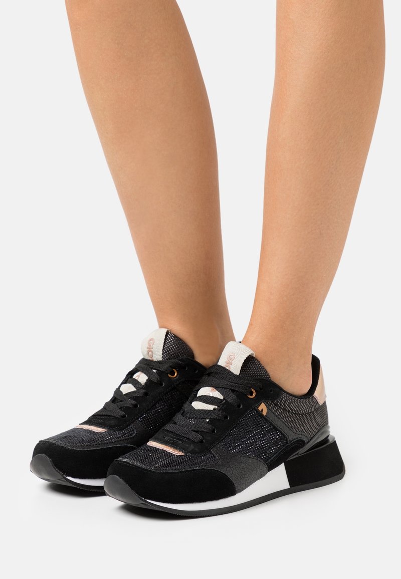 Scarpe sportive nere e argento con tomaia in rete, dettagli in suede e suola tessurizzata. Il design include dettagli bianchi e rosa.