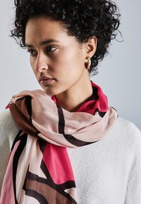 Sciarpa morbida e stampata, con colori rosa, marrone e nero, realizzata in tessuto leggero, drappeggiata attorno al collo.