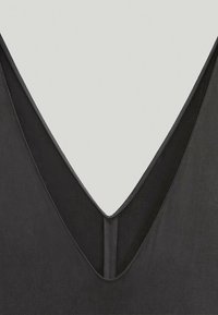 Sort v-hals top med en dyb udskæring og glat tekstur. Har kontrasterende tynde sømme langs halsudskæringen for ekstra detaljer.