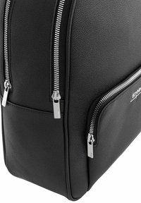 Czarna torebka ze strukturalnej skóry z teksturą, z srebrnymi elementami, wyposażona w dwie zamykane na zamek przegrody i gładką, zorganizowaną formę.