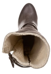 Botte en cuir marron avec un ajustement serré, doublure en tissu polaire crème douce, bout arrondi et une sangle décorative au niveau de la cheville. Texture extérieure lisse.