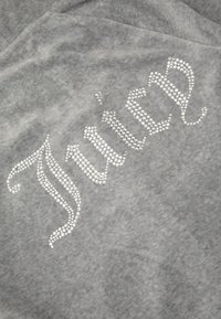 Sivi dukserica od tkanine s natpisom "Juicy" u srebrnim cirkonima s kursevnim dizajnom i glatkom teksturom.