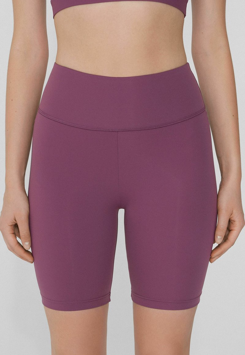 Pantaloni bike a vita alta di colore viola realizzati in tessuto elasticizzato, caratterizzati da una superficie liscia e cuciture a contrasto lungo le cuciture.