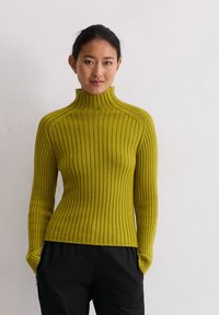 Rippenteil-Turtleneck-Pullover in leuchtendem Gelb-Grün, mit langen Ärmeln und tailliertem Design. Der Stoff wirkt weich und hat eine strukturierte Oberfläche.