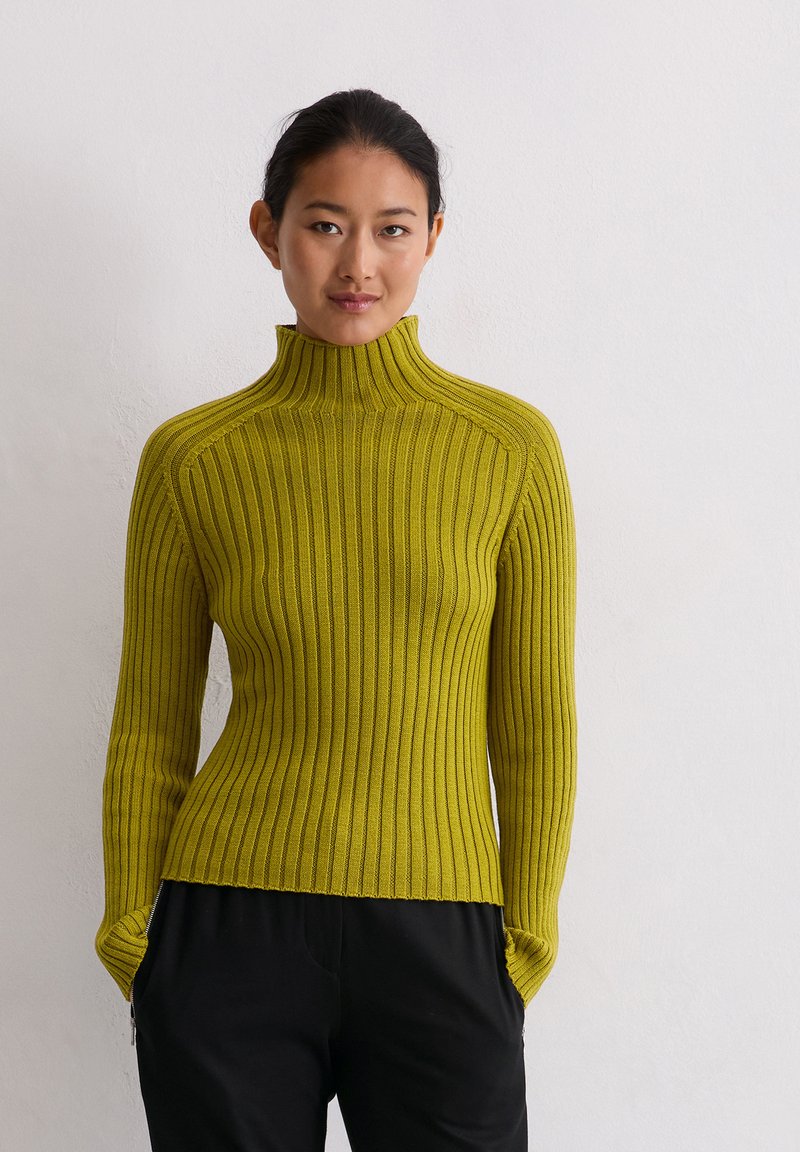 Rippenteil-Turtleneck-Pullover in leuchtendem Gelb-Grün, mit langen Ärmeln und tailliertem Design. Der Stoff wirkt weich und hat eine strukturierte Oberfläche.