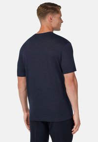 Mörkblå t-shirt med kort ärm i ett mjukt, lätt material. Har rund hals och en slät textur med minimala designdetaljer.
