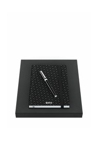 Carnet noir texturé avec bande élastique et logo "BOSS" argenté, accompagné d'un stylo noir et argent posé sur une boîte noire.