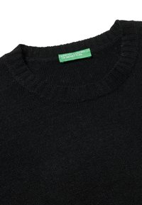 Schwarzer Strickpullover mit rundem Halsausschnitt und gerippten Bündchen. Mit einem grünen Etikett mit der Aufschrift "UNITED COLORS OF BENETTON." Glatte Textur.