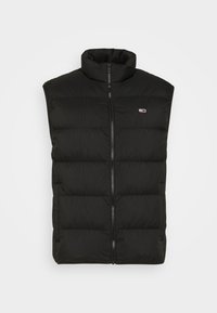 Svart ärmlös puffer-väst med hög krage, dragkedjeslutning och kviltad design. Har en diskret logotyp på bröstet. Slät textur.