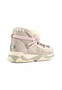 Stivale alla caviglia metallico color beige chiaro con fodera in pelliccia, lacci rosa e cuciture decorative. Presenta una suola spessa bianca e grigia testurizzata.