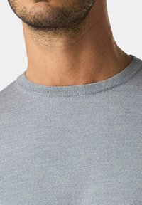T-shirt azzurro chiaro a girocollo realizzato in morbido tessuto a maglia; presenta una texture liscia e un colletto a costine per un tocco di dettaglio in più.