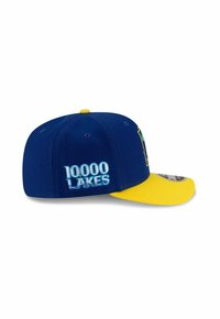 Casquette bleue avec un bord jaune, arborant "10000 LACS" brodé en bleu clair. Elle a une conception structurée avec des œillets pour la ventilation.