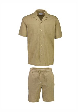 Camicia beige chiaro a maniche corte e pantaloni corti abbinati; tessuto strutturato con due tasche frontali; vestibilità comoda e vita elasticizzata sui pantaloni.