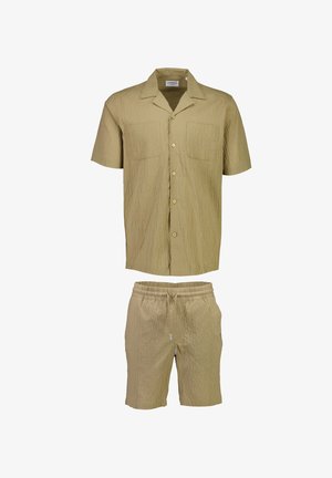 Chemise légère beige à manches courtes et shorts assortis ; tissu texturé avec deux poches avant ; coupe décontractée et taille élastique pour les shorts.