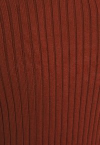 Geribbelde gebreide stof in een diepe rode kleur, met verticale strepen, een zachte textuur en gelijkmatige stiksels over de hele stof.