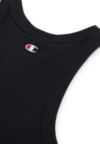 Camiseta sin mangas negra de algodón con cuello acanalado. Presenta un pequeño logo bordado en azul, rojo y blanco en el pecho.