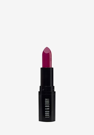 Rouge à lèvres violet foncé dans un tube noir avec "LORD & BERRY" imprimé sur le boîtier inférieur, présenté sur un fond uni gris clair.