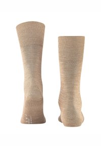 Calcetines beige hasta media pantorrilla hechos de tela suave y texturizada con parte superior acanalada. Acabado liso con un patrón sutil y talón reforzado para mayor durabilidad.