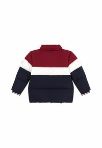 Doudoune avec un design coloré en blocs bordeaux, blanc et marine, dotée d'un col haut, d'une texture matelassée et de poignets côtelés.