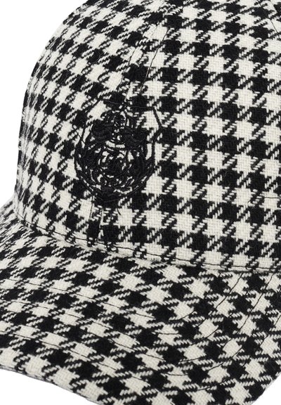 Črna in bela šahovnica kapa s teksturiranim houndstooth vzorcem, ki ima na sprednji strani črn izvezen logotip.