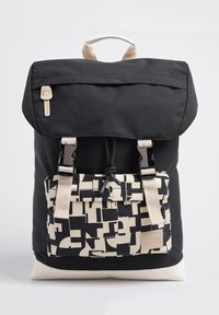 Mochila de tela negra con solapa plegable, correas ajustables y un bolsillo frontal con patrón beige y detalles de hardware.