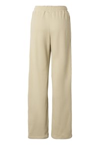 Pantalon large côtelé beige avec taille élastique et sans poches visibles, vu de dos sur fond blanc.