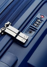 Valigia blu navy con superficie testurizzata, dotata di doppia cerniera, lucchetto a combinazione e una serratura approvata dalla TSA.