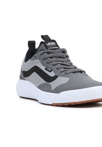 Gray athletic shoe with a mesh upper, black accents, white midsole, and textured rubber outsole. Features a lace-up design and pull tab.