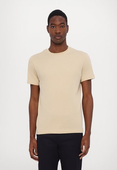Beige cotton t-shirt with a crew neckline and short sleeves, featuring a soft texture and a fitted shape. Slightly longer back hem.