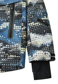 Chaqueta impermeable con una tela de patrón azul, negra y blanca con diseños circulares, bolsillos con cremalleras y puños ajustables.