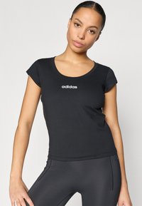 Μαύρο εφαρμοστό μπλουζάκι με στρογγυλή λαιμόκοψη και κοντά μανίκια, με λευκό λογότυπο "adidas" στο κέντρο του στήθους. Λεπτή υφή.