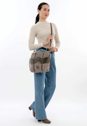Borsa in pelliccia sintetica nelle tonalità di grigio, con un design trapuntato, tracolla regolabile e chiusura con coulisse. Superficie morbida e testurizzata.