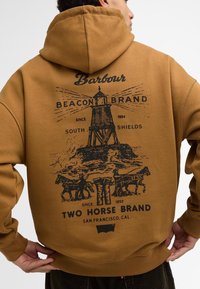 Καφέ φούτερ με μεγάλη μαύρη γραφική παράσταση που απεικονίζει ένα φάρο και άλογα. Το κείμενο περιλαμβάνει "Barbour," "Beacon Brand," και "Two Horse Brand."