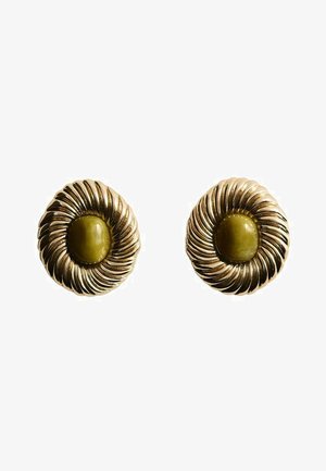 Boucles d'oreilles en ton or mettant en avant un design spiralé avec une pierre centrale de couleur vert olive. Texturées, avec une finition brillante et en forme circulaire.