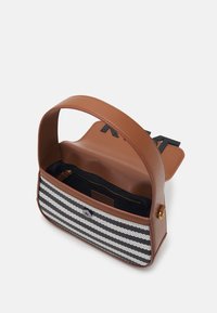 Brun läderhandväska med en svartvit randig textilframsida, innerficka med dragkedja och bred axelrem för bärande.