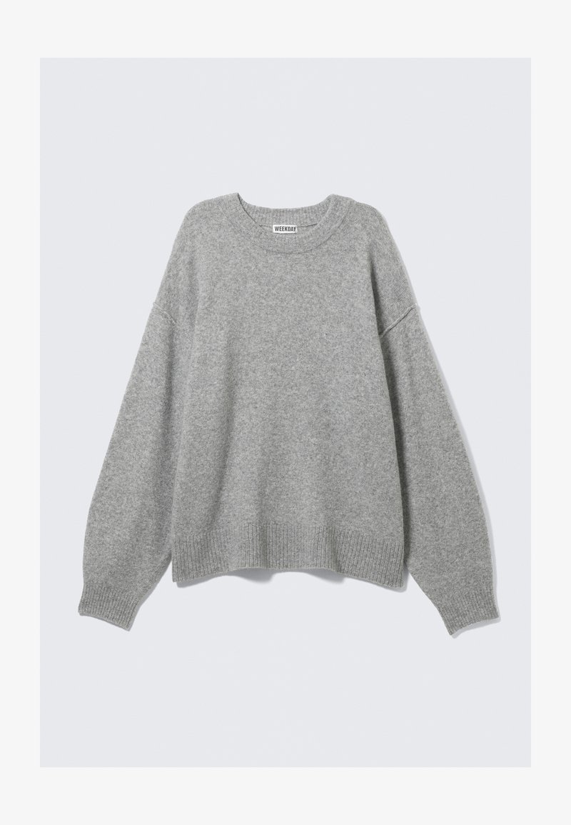 Pull en tricot gris clair avec un col rond, des épaules tombantes et des poignets et ourlet côtelés. Texture douce avec une coupe décontractée et oversize.