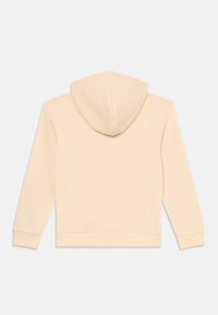 Felpa beige con cappuccio e maniche lunghe, con polsini a coste, vista da dietro su uno sfondo bianco.