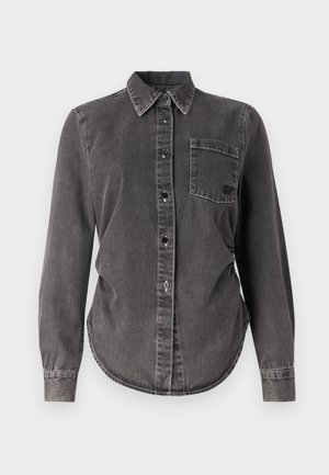 Camisa de denim gris oscuro con mangas largas, cierre de botones, cuello puntiagudo, bolsillo en el pecho y dobladillo redondeado. Superficie texturizada con costuras visibles.