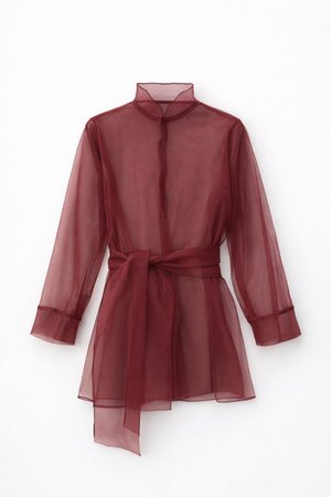 Bluză transparentă burgundy cu guler mandarin, mâneci lungi și curea cu fundă în talie. Material ușor, cu textură netedă.
