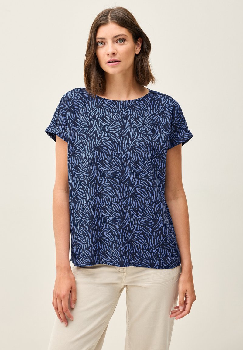 Haut à manches courtes bleu marine ornée d'un motif de feuilles dans des tons de bleu clair. Tissu doux avec un col rond et une coupe décontractée.