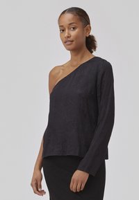 Black, textured, one-shoulder top with long sleeve and a relaxed fit, made from a lightweight fabric. Smooth surface, minimal detailing.