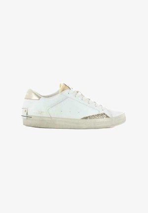 Sneaker bianco in suede con una finitura testurizzata, accenti metallici dorati, tre occhielli per i lacci e un dettaglio glitterato sul lato. Suola in gomma.