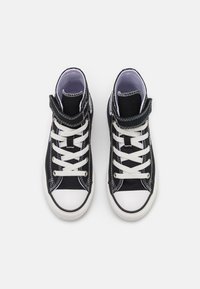 Czarne kanwy sportowe buty za kostkę z białymi sznurówkami i gumową osłoną na palce, z kontrastowym przeszyciem i wyściełanym kołnierzem dla wsparcia.